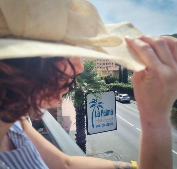 Foto di una cliente affacciata al balcone del Residence La Palma