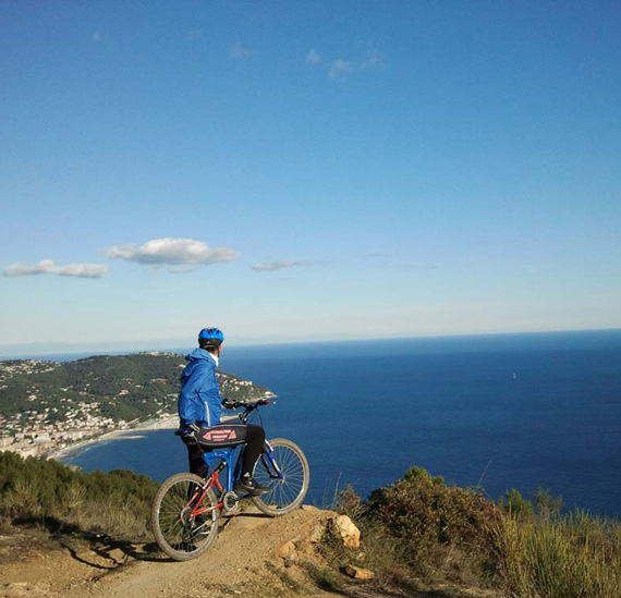 Photo of a man on a mountain bike overlooking the sea of Andora